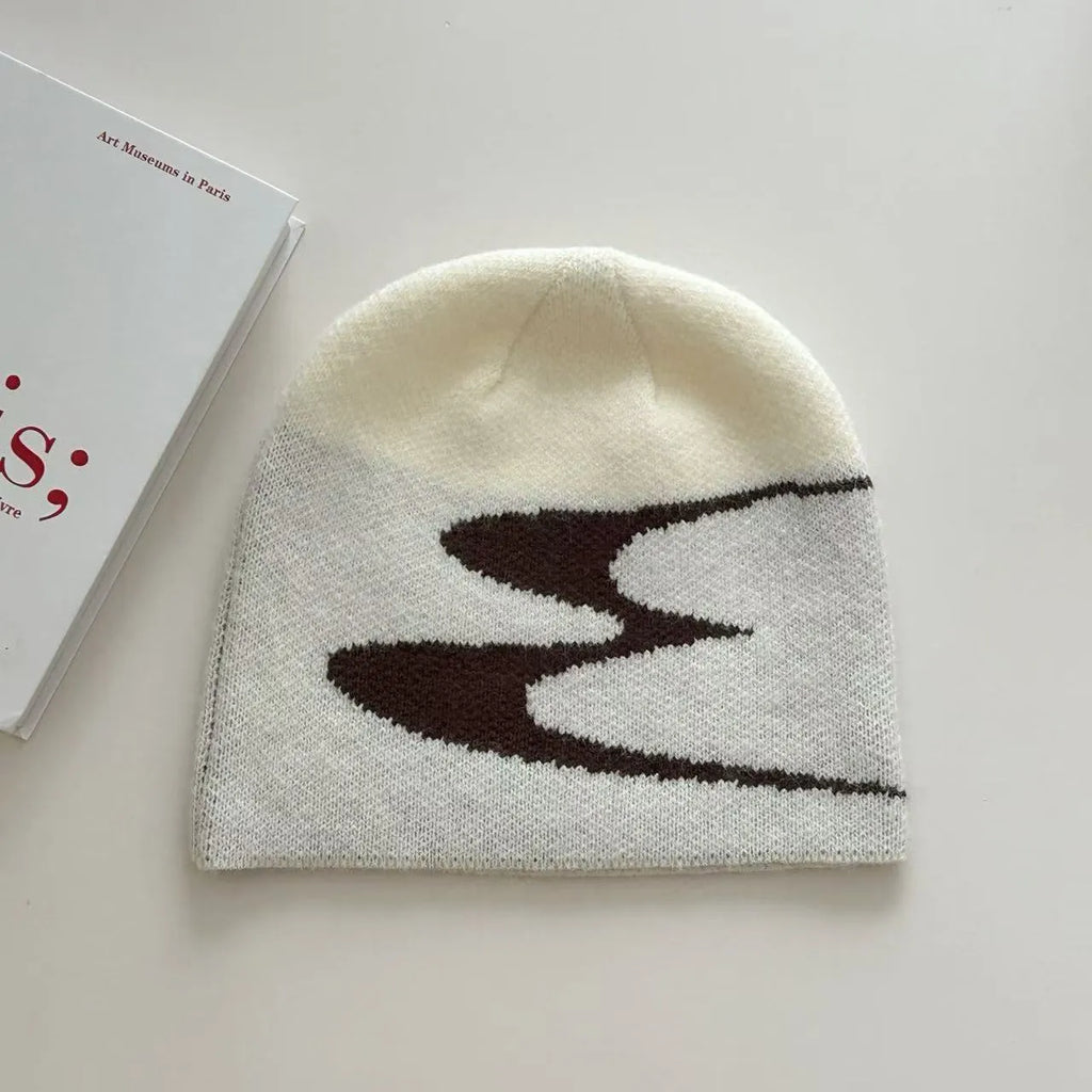 A knitted acrylic beanie hat in black, shown on a model, for autumn and winter wear.