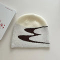 A knitted acrylic beanie hat in black, shown on a model, for autumn and winter wear.