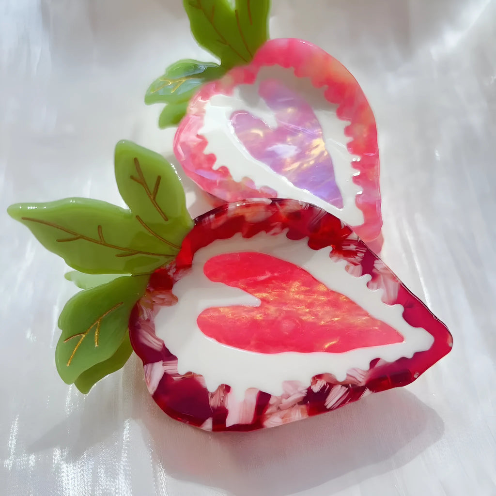 Handmade red and pink strawberry hairpin for girls on a white background.