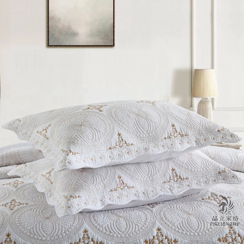 European-style embroidered pure cotton bed cover set with two pillowcases on a bed.