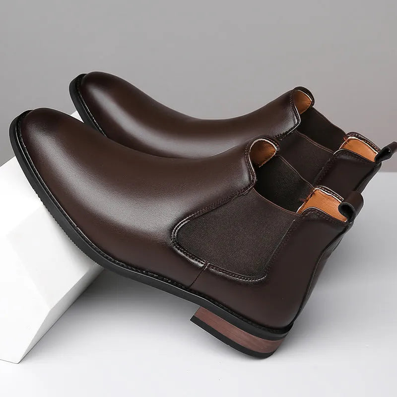 Men's black pointed-toe Chelsea boots with a low heel and rubber sole on a white background.