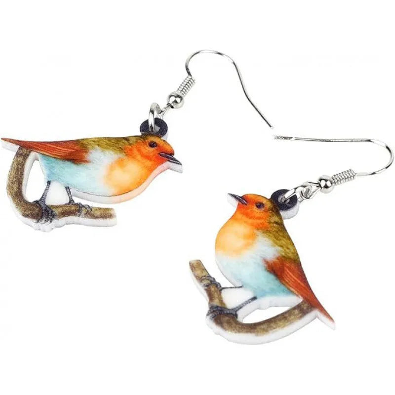 A pair of blue, white, and black acrylic drop earrings featuring a detailed Blue Tit bird and geometric snake patterns on a white background.