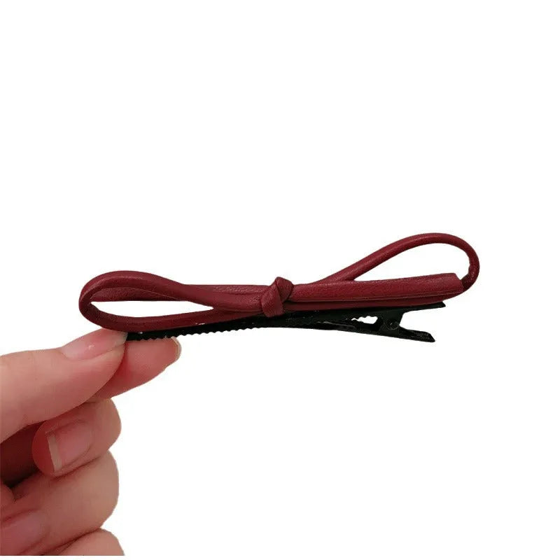 Handmade wine red leather bow barrette on a metal hair clip, showing the 5.5cm wide bow shape.