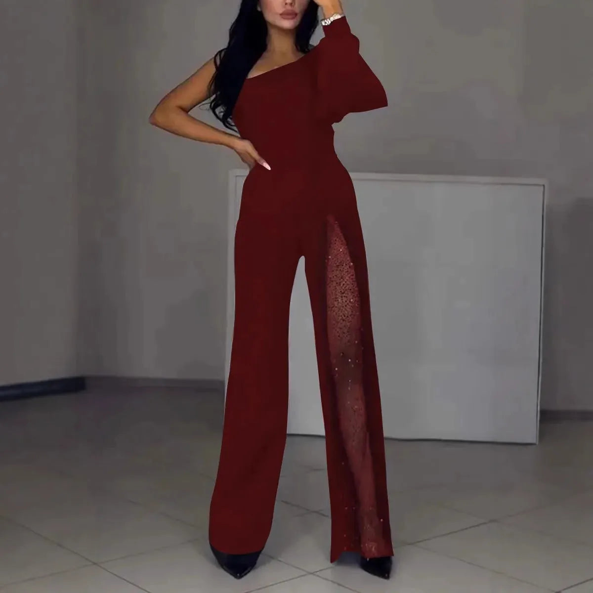 Black women's long sleeve jumpsuit with oblique shoulder neckline and high leg slit.