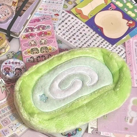 Honeydew green velvet pencil case with Swiss roll cake design, shown rolled up.