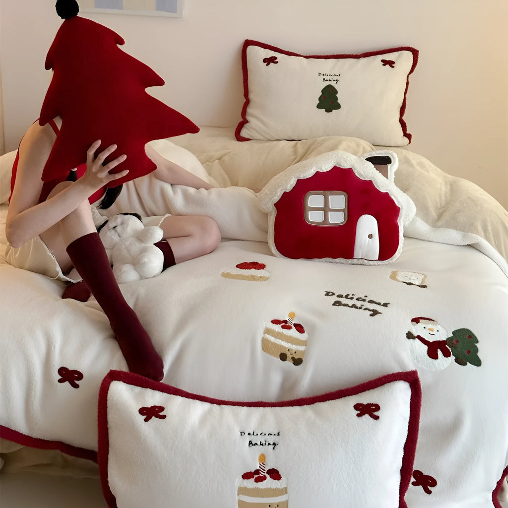 Cartoon pattern winter bedding four-piece set including bed sheet, duvet cover, and pillowcases on a bed.