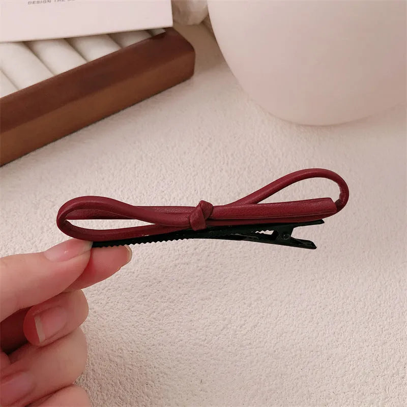 Handmade wine red leather bow barrette on a metal hair clip, showing the 5.5cm wide bow shape.