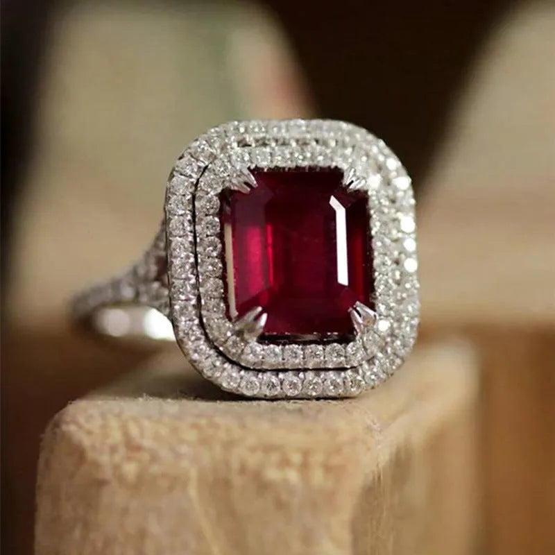 Copper square women's ring with a central red rhinestone on a hand model.
