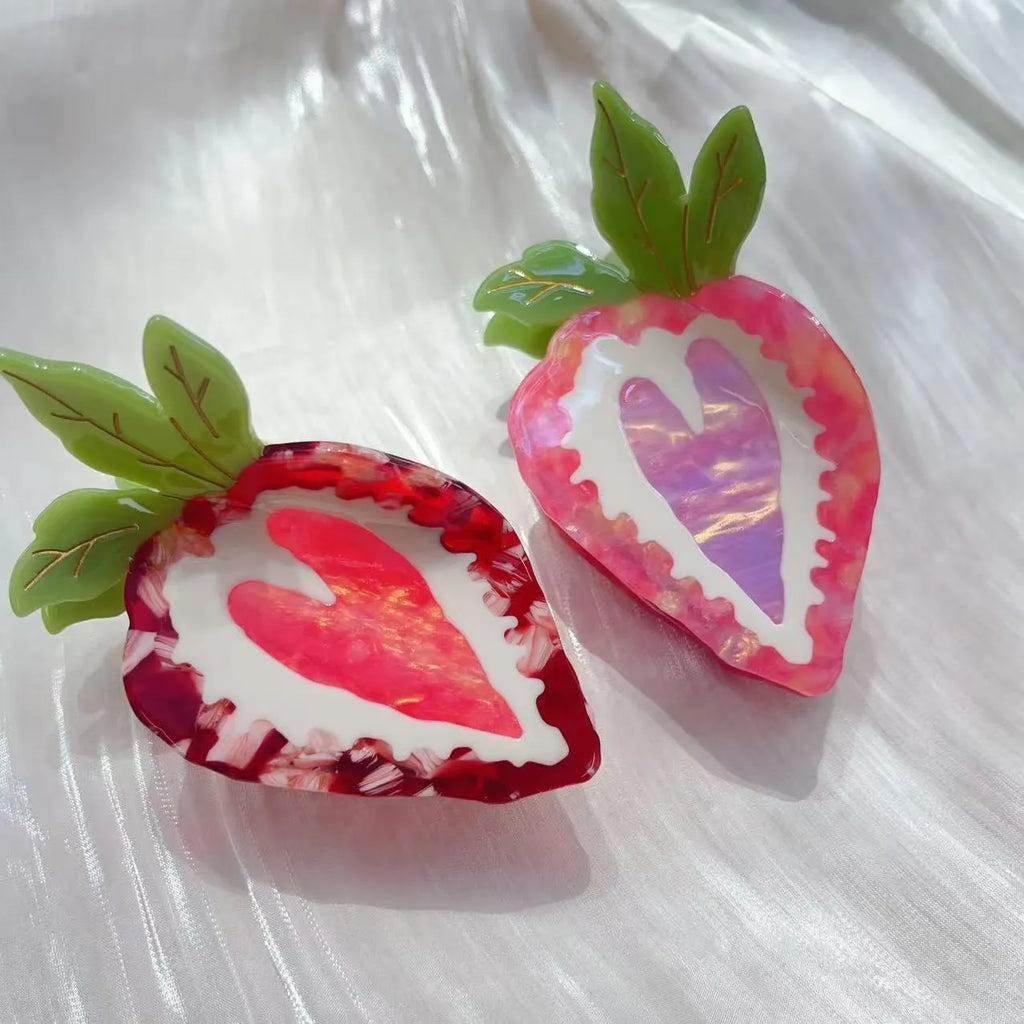 Handmade red and pink strawberry hairpin for girls on a white background.