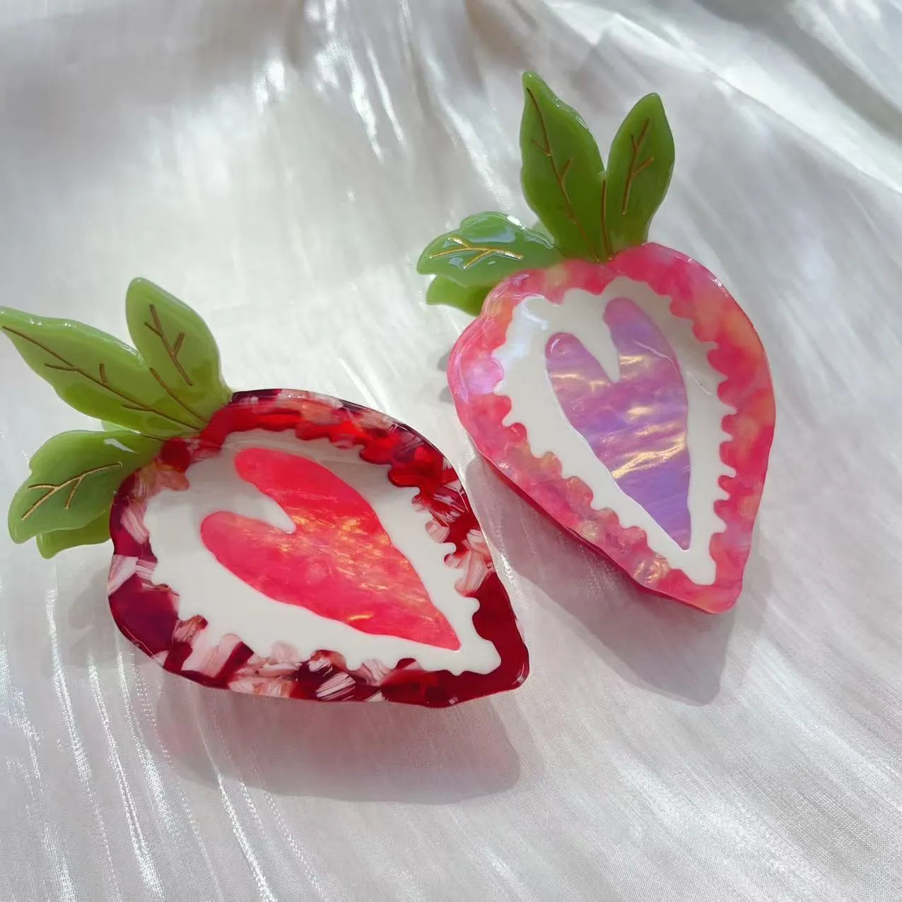 Handmade red and pink strawberry hairpin for girls on a white background.
