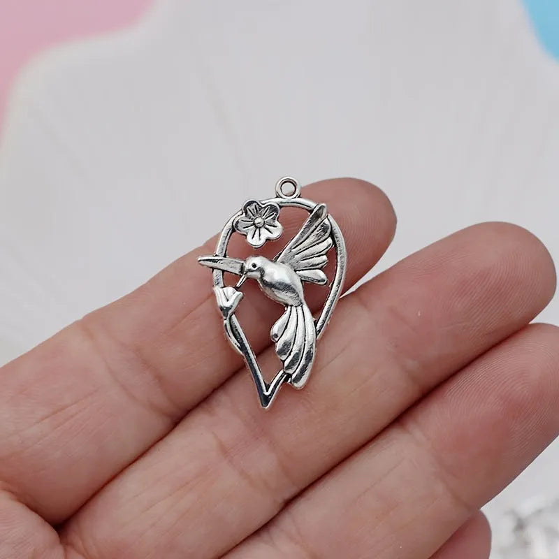 Gold tone alloy pendant with a detailed cast magpie design, shown from the front and back.