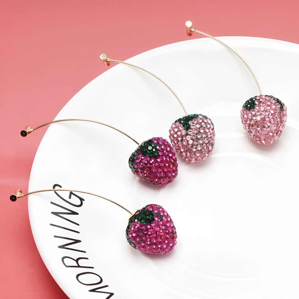 A pair of red geometric strawberry stud earrings with a faceted surface and butterfly clutch fastenings.