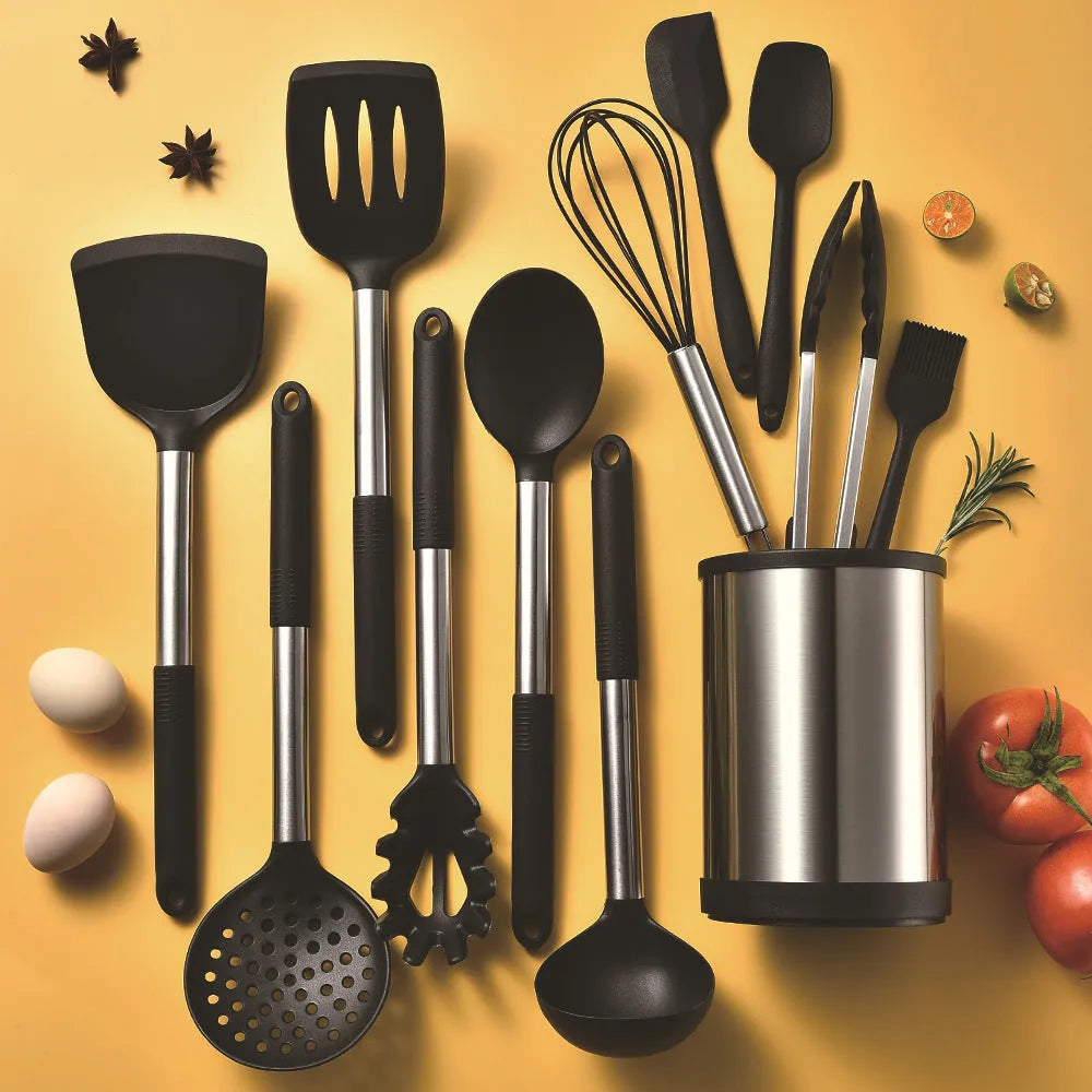 Black silicone kitchen utensil set with 12 tools stored in a rotating plastic storage bucket on a worktop.