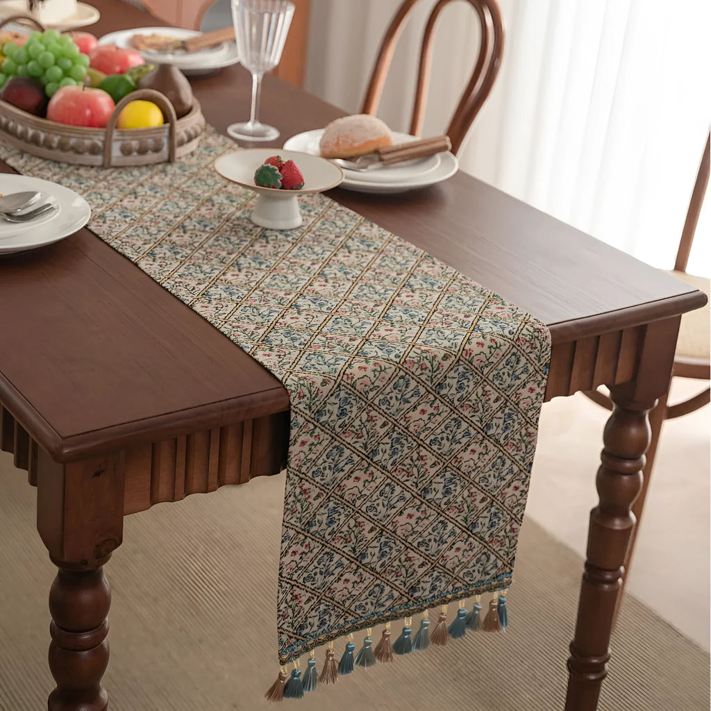 Nordic striped jacquard table runner with tassel on a dark wooden dining table.