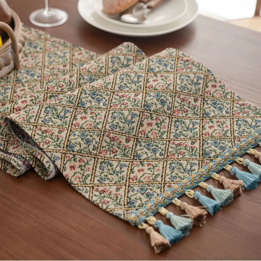 Nordic striped jacquard table runner with tassel on a dark wooden dining table.