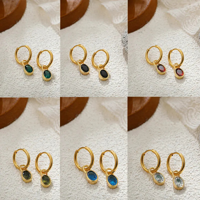 Close-up of women's retro-style copper earrings featuring a single oval-cut zircon stone in an emerald green colour.