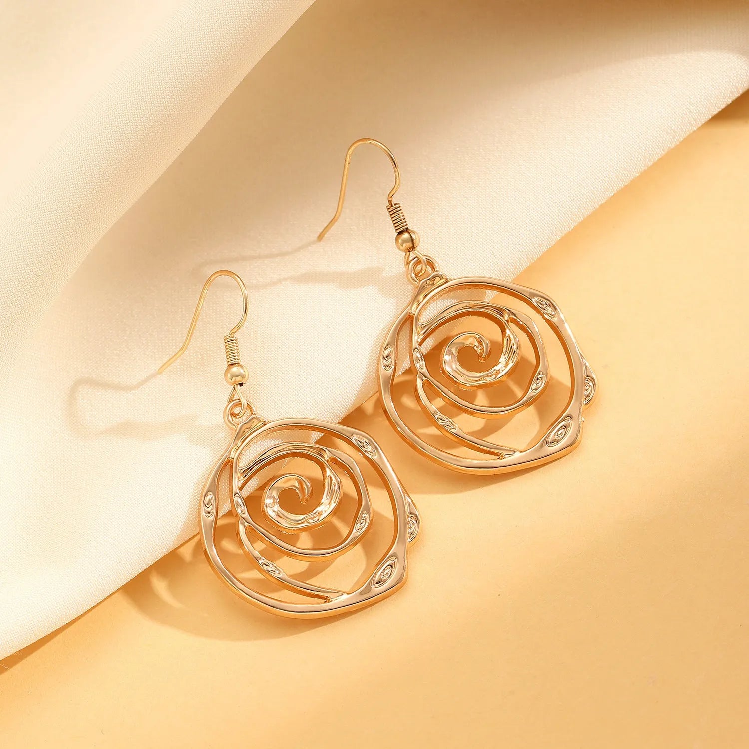 Spiral donut design women's jewellery set showing matching necklace, bracelet, and ear hooks in gold electroplated finish