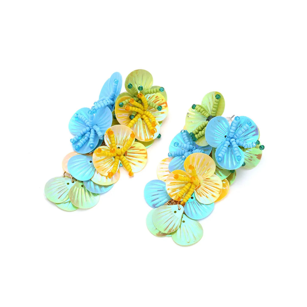 Handmade exaggerated string bead flower earrings in colourful, rose, or purple on a white background.