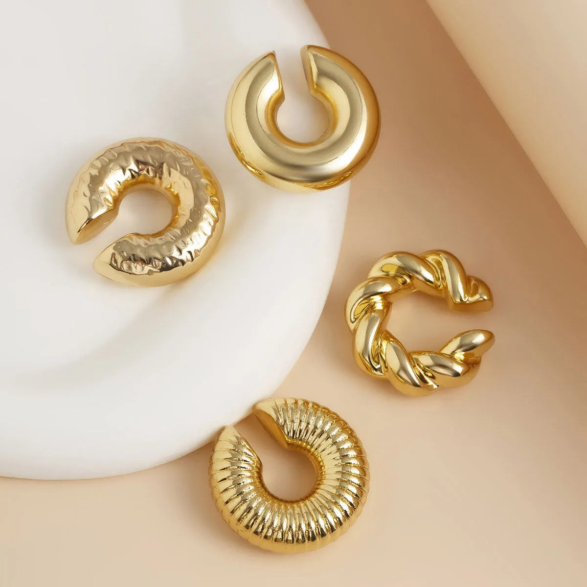 Set of four geometric clip-on earrings for women in gold and silver finishes.