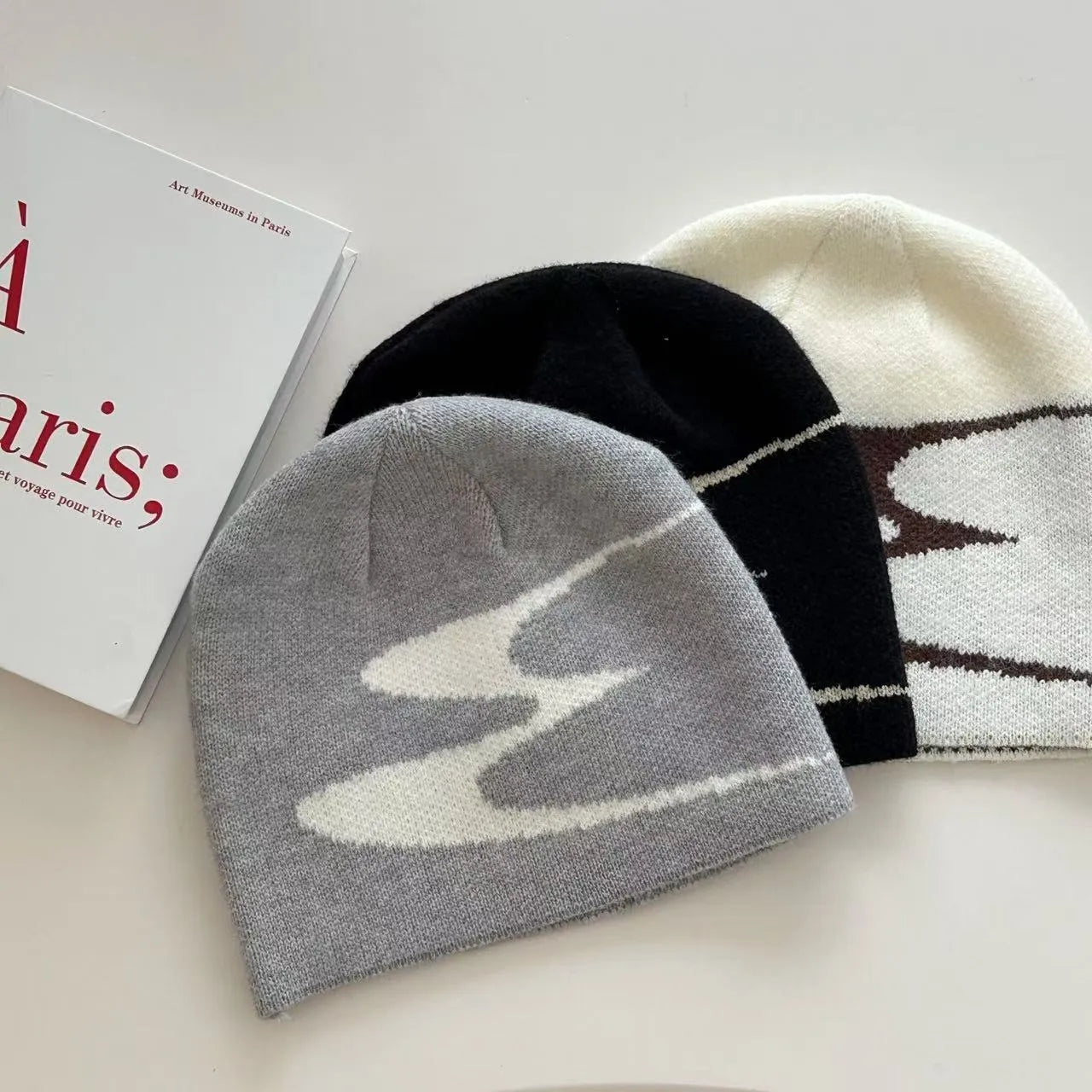 A knitted acrylic beanie hat in black, shown on a model, for autumn and winter wear.