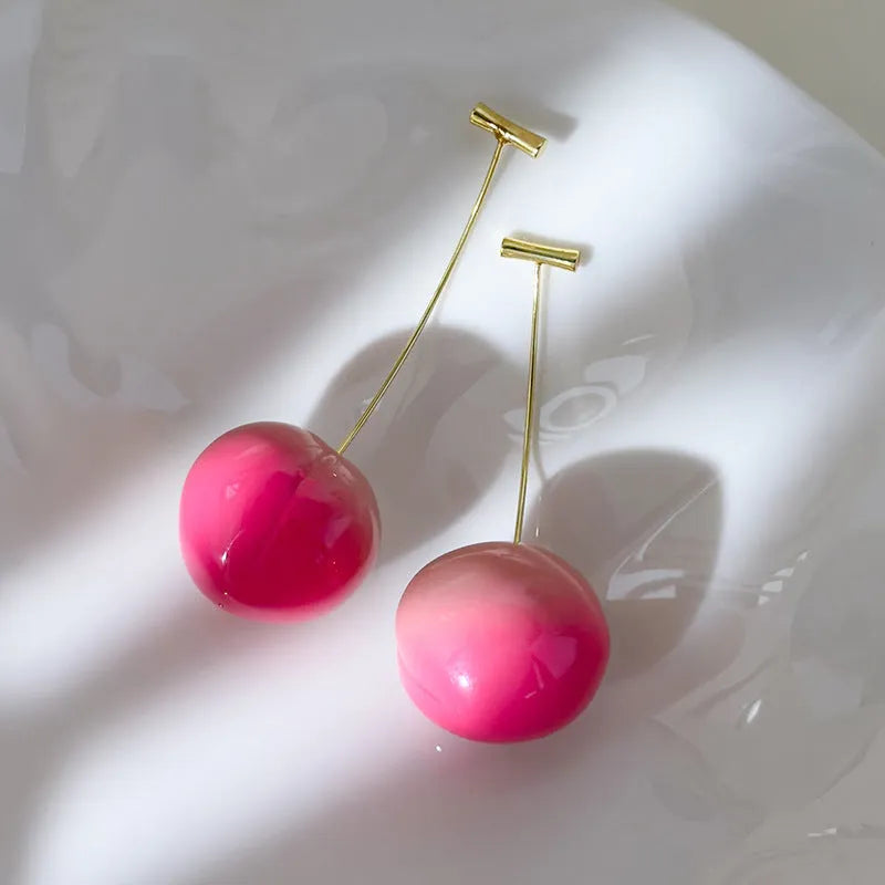 A pair of acrylic peach-shaped earrings with copper fittings, shown in small and large size options.