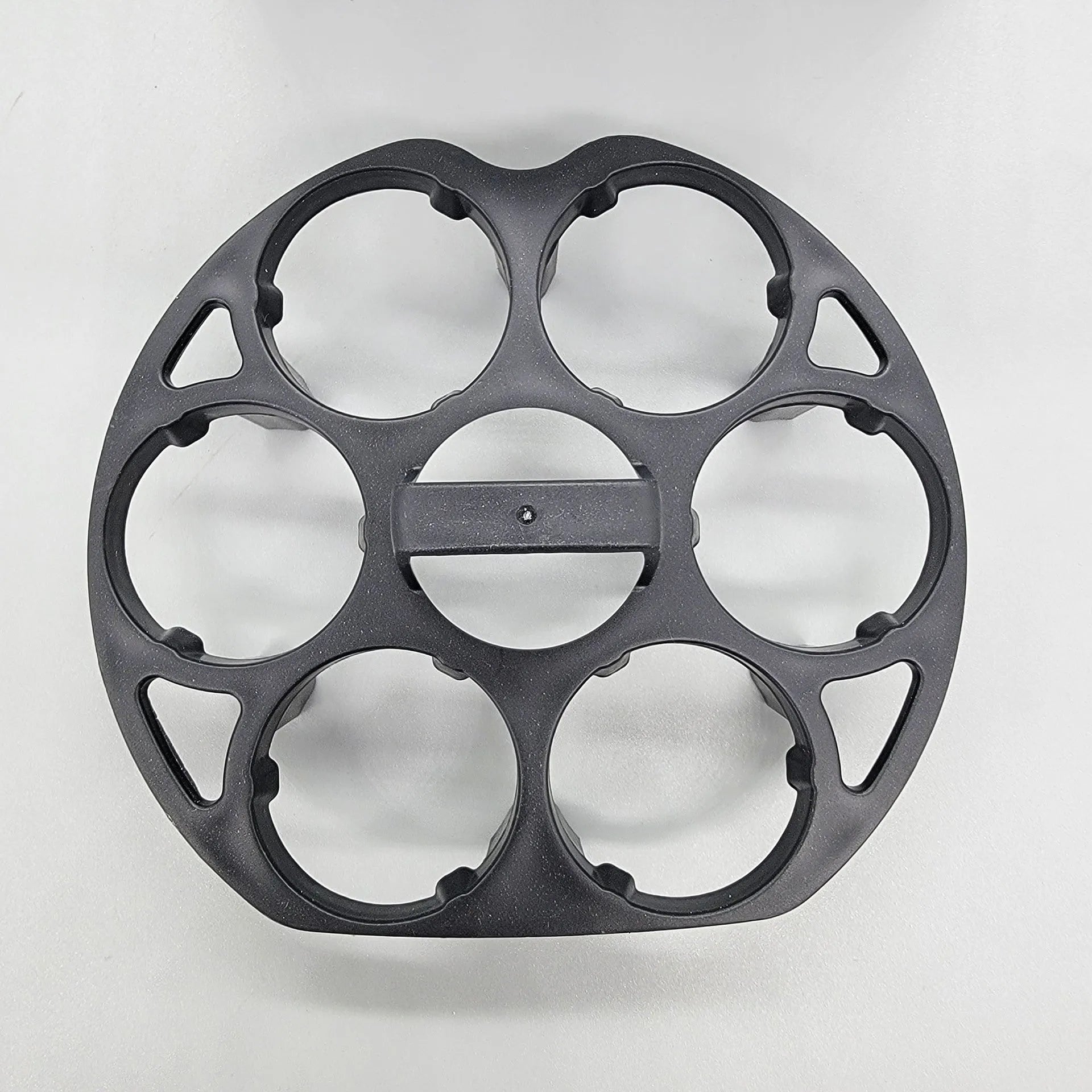 Black plastic egg holder cooking basket rack with retainer on a kitchen counter.
