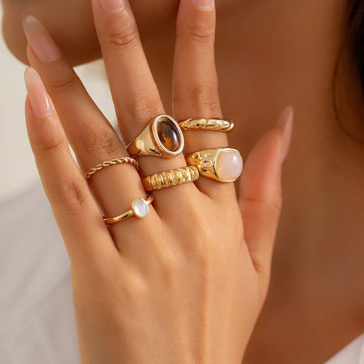 Six geometric irregular shaped alloy rings in light gold electroplated finish displayed together