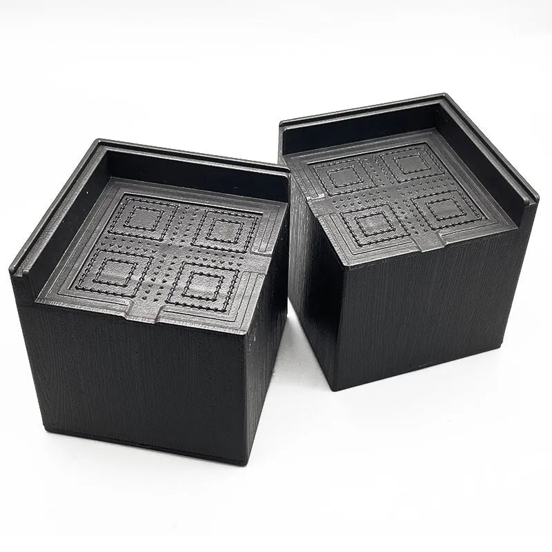 Four black plastic bed foot mats for increasing sofa or furniture height.