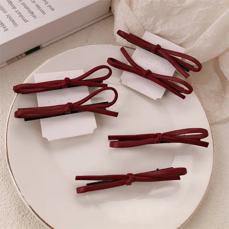 Handmade wine red leather bow barrette on a metal hair clip, showing the 5.5cm wide bow shape.
