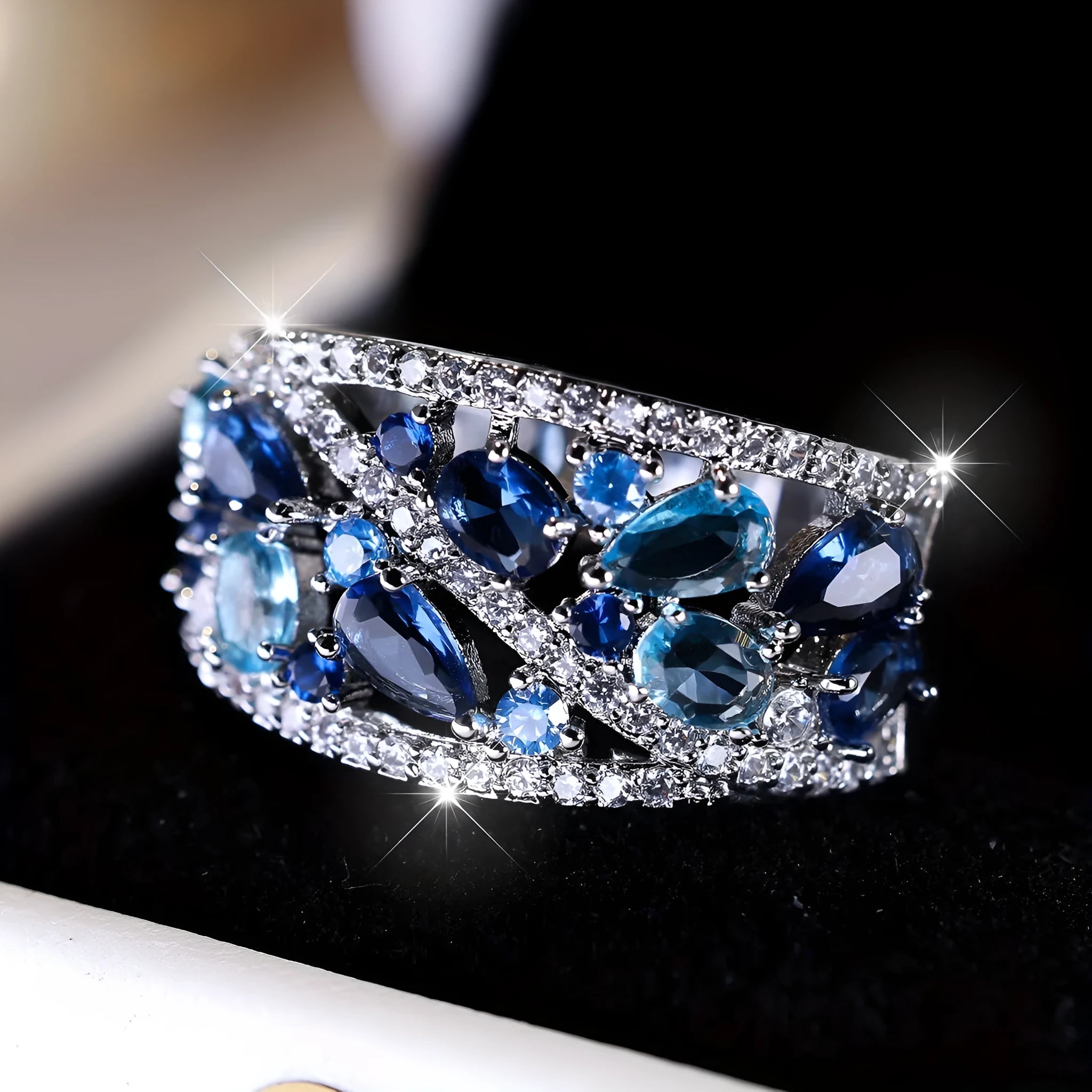 Women's round hollow fashion ring in gold and platinum colours with blue or white stone accents.