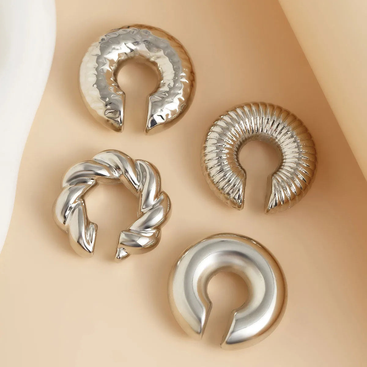 Set of four geometric clip-on earrings for women in gold and silver finishes.