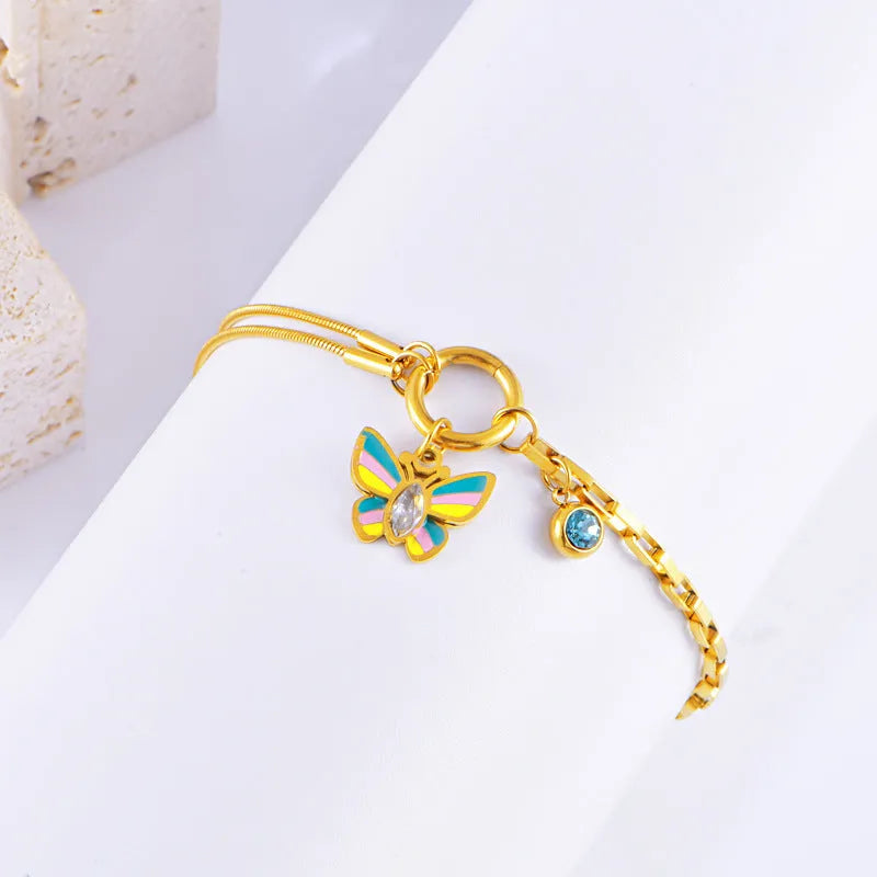 Gold tone titanium steel necklace and bracelet set with colourful epoxy butterfly pendants on a snake bone chain.