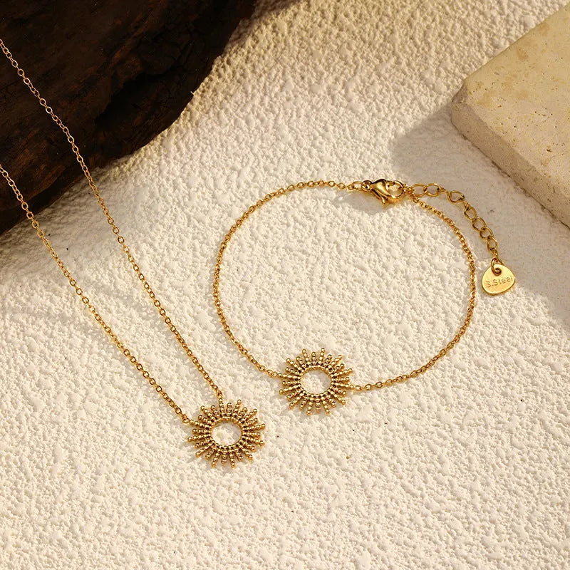 Gold-coloured SUNFLOWER Series necklace and bracelet set with chain links on a white background.