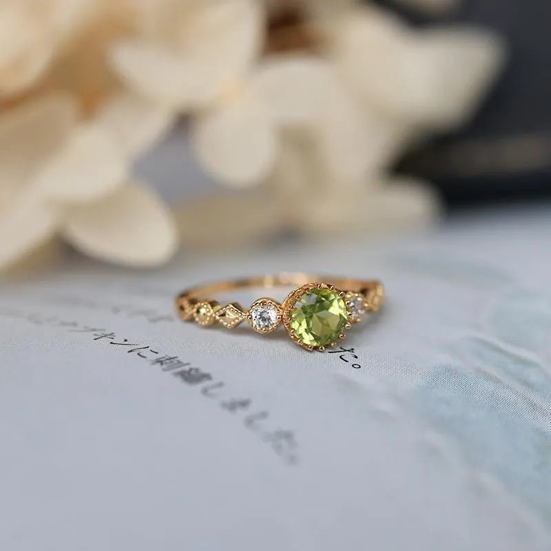 Japanese style geometric copper ring with imitation peridot stone on a model's finger.