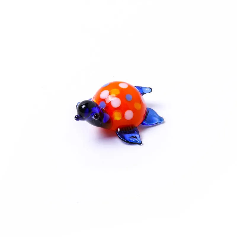 Modern geometric glass turtle ornament on a desk in blue head and blue shell colour variation.
