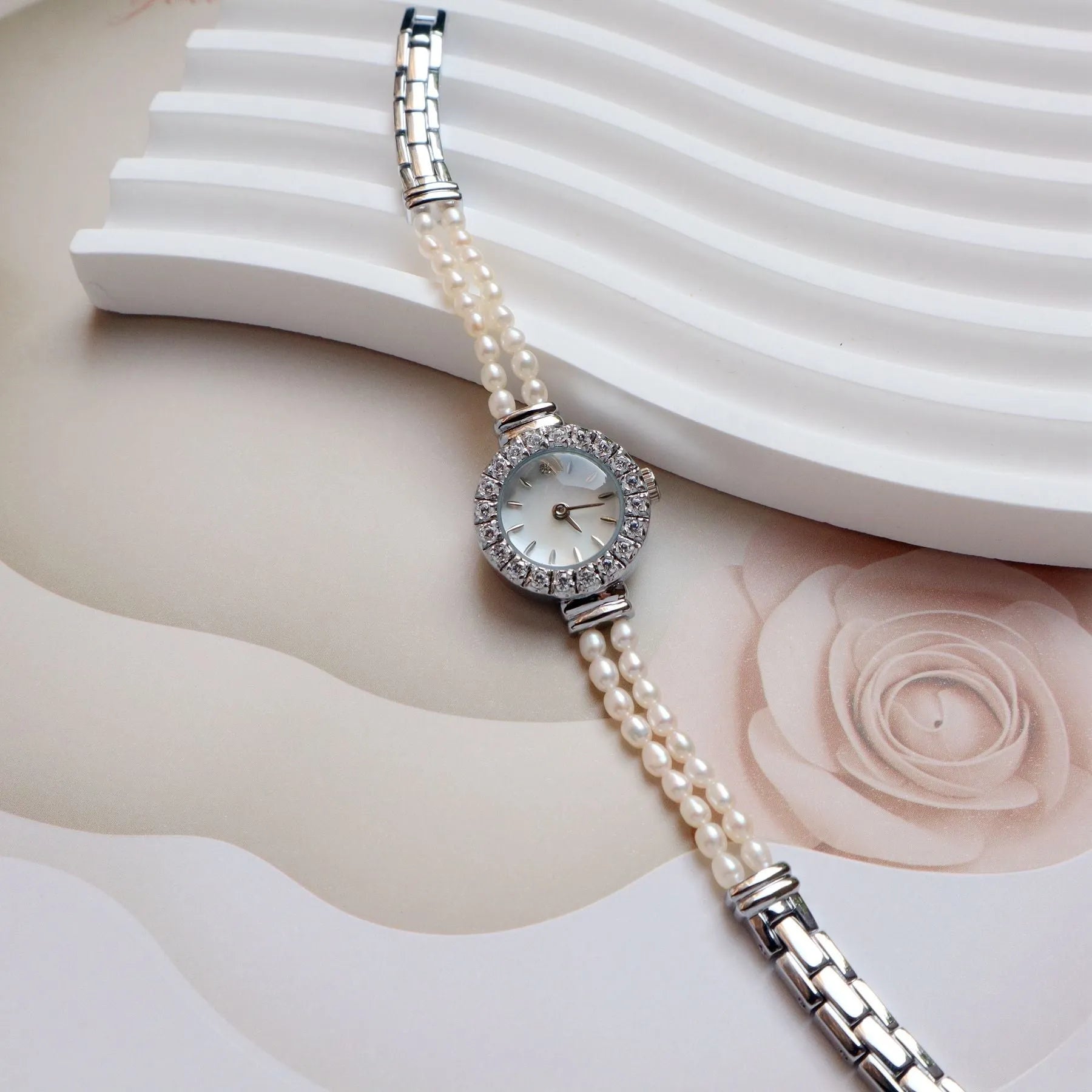 Light gold women's freshwater pearl bracelet watch with round dial on stainless steel strap.