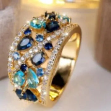 Women's round hollow fashion ring in gold and platinum colours with blue or white stone accents.