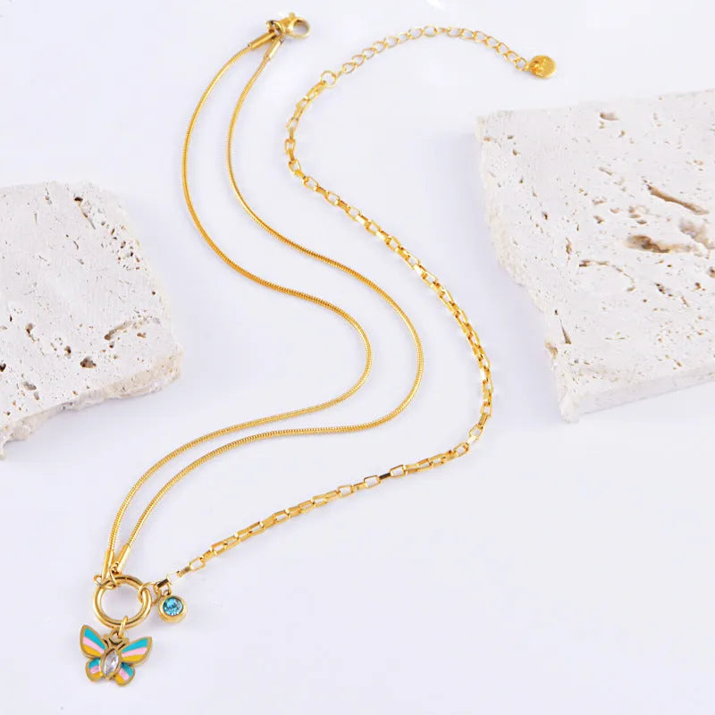 Gold tone titanium steel necklace and bracelet set with colourful epoxy butterfly pendants on a snake bone chain.