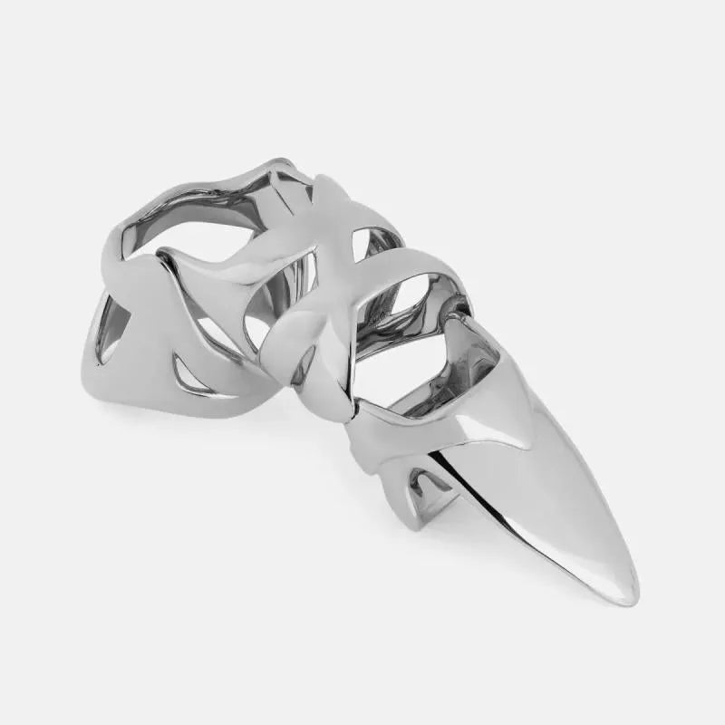 Silver-coloured metal finger cover with punk armour design shown on a model's finger.