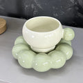 Ceramic coffee mug and saucer set in a solid colour on a table.