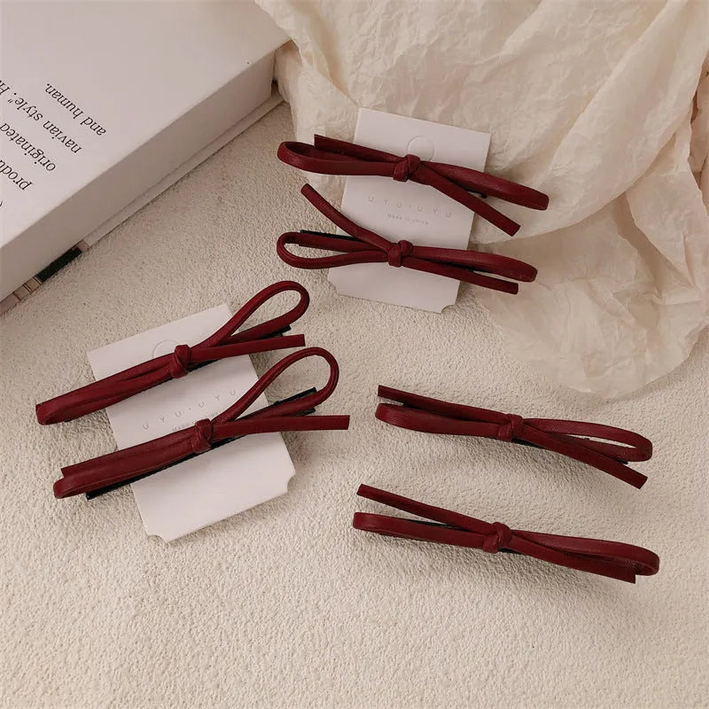 Handmade wine red leather bow barrette on a metal hair clip, showing the 5.5cm wide bow shape.