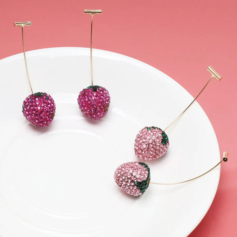 A pair of red geometric strawberry stud earrings with a faceted surface and butterfly clutch fastenings.