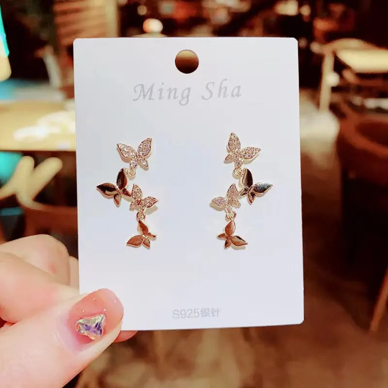 Gold-colour women's drop earrings with four butterfly charms made from copper