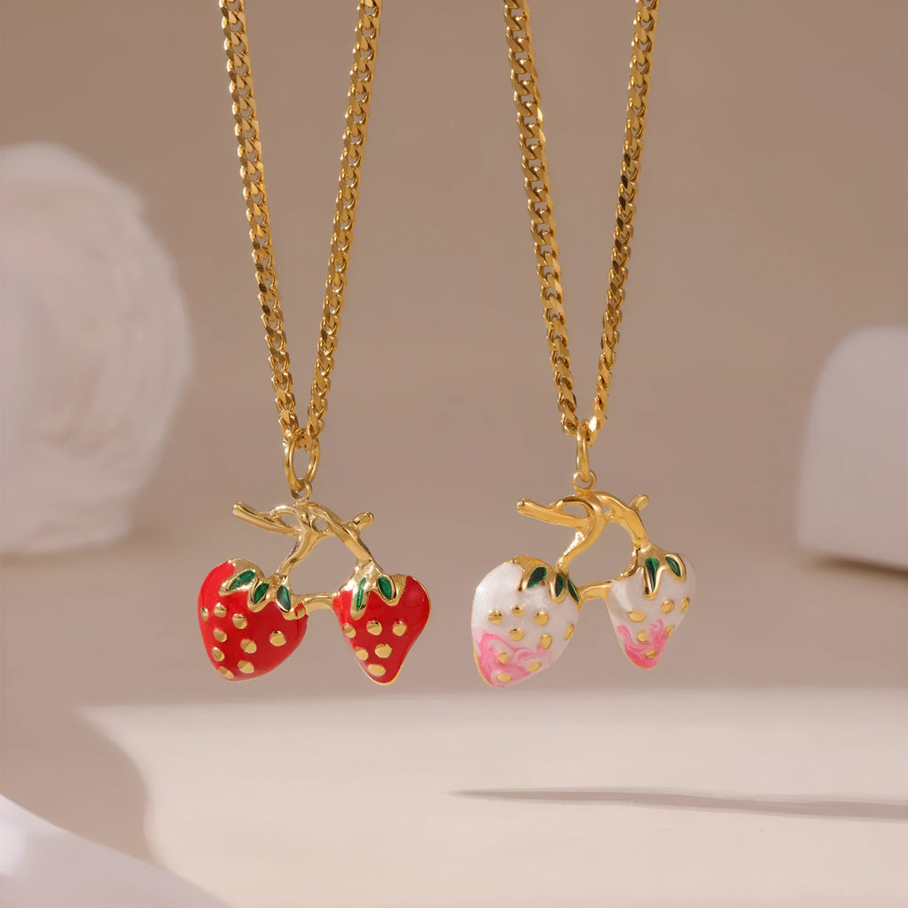 Close-up of a women's stainless steel necklace with a small red strawberry fruit pendant on a silver chain.