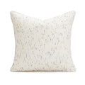 A square solid-colour cushion pillow on a sofa, showing its plain edge detail.