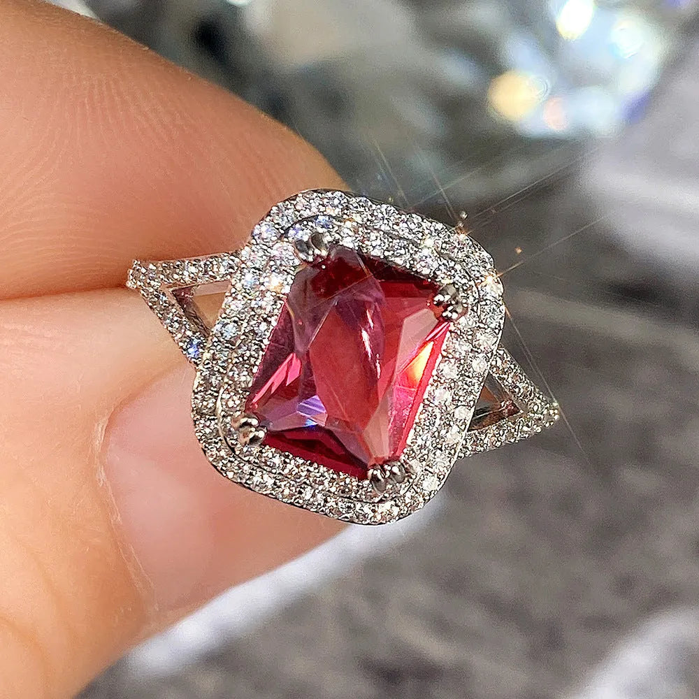 Copper square women's ring with a central red rhinestone on a hand model.
