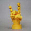 Yellow PLA movable joint hand prop ornament on a flat surface, showing articulated fingers.