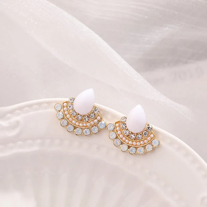 A pair of women's silver retro fan-shaped earrings with rhinestone and opal-like geometric details.