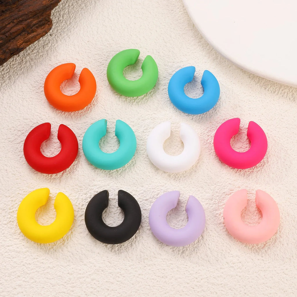 Round C-shaped clip-on earring with a matte coarse surface in a selection of candy colours.