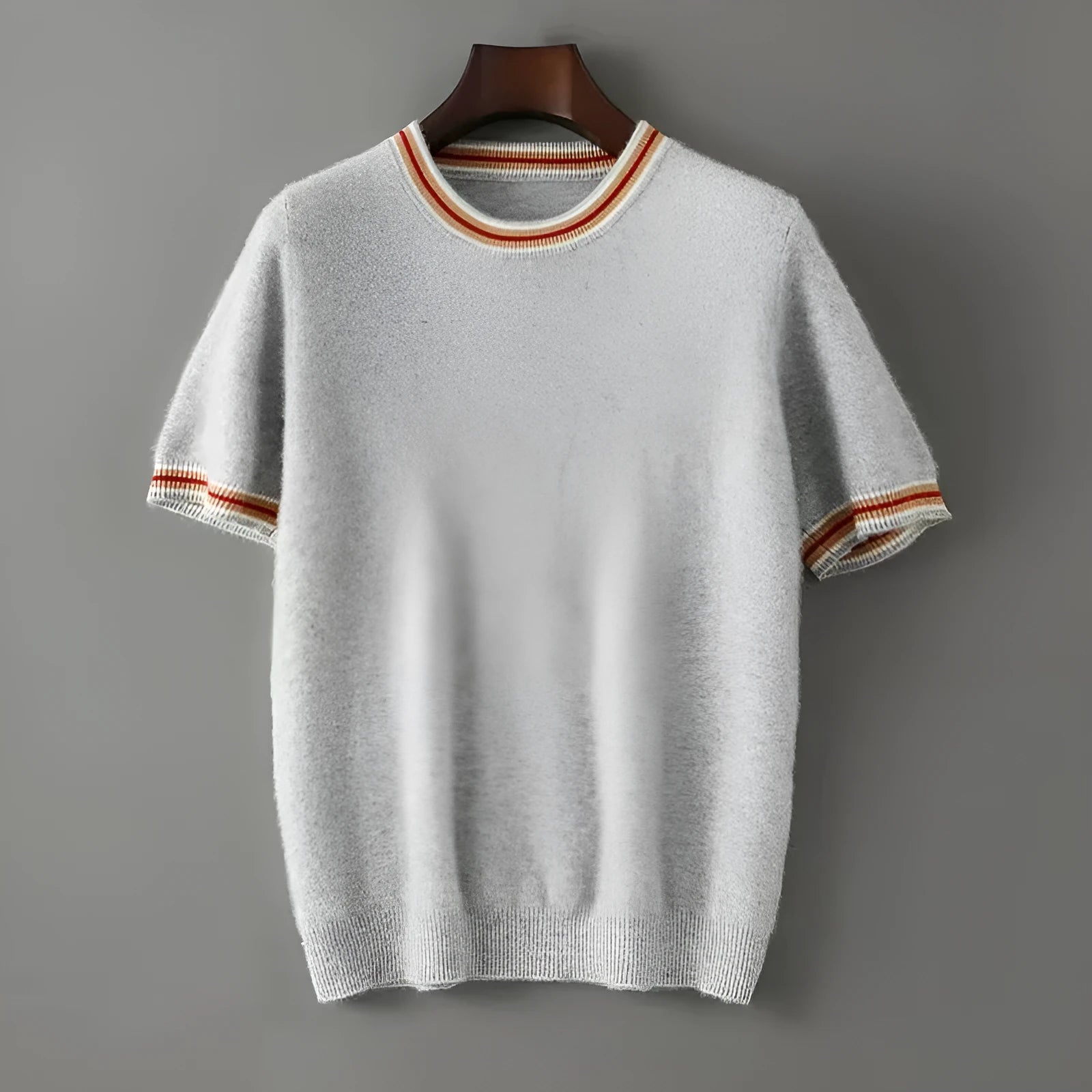 A man's short sleeve grey wool jumper with a round neckline on a hanger.